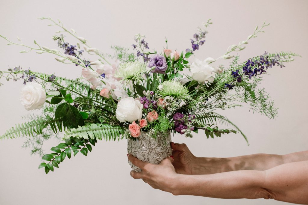 Holding a vase of beautiful fresh flowers