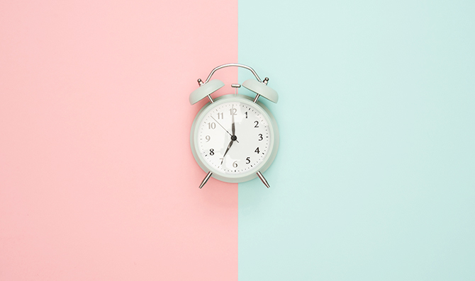 Pink and blue background with alarm clock